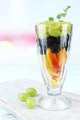 fresh tasty fruit salad on blue wooden table