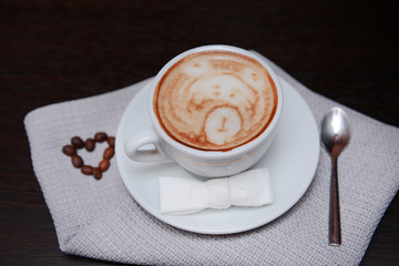 Cup of coffee with cute drawing in cafe
