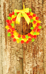 Beautiful wreath of candies hanging on old wooden door