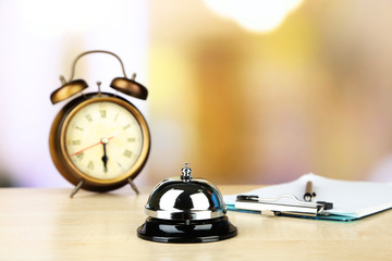 Reception bell on hotel reception desk, on bright background