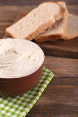 Fresh homemade butter in bowl and sliced bread,