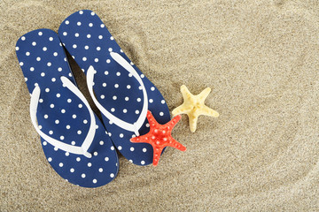 Flip flops on sea sand background