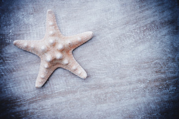 Fototapeta na wymiar Starfish on old wood background with copy space