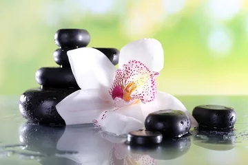 Photo sur Plexiglas Orchidée Pierres de spa et orchidée blanche sur table sur fond naturel
