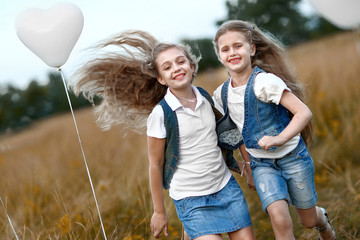 portrait of a little girls in a field with white balloons