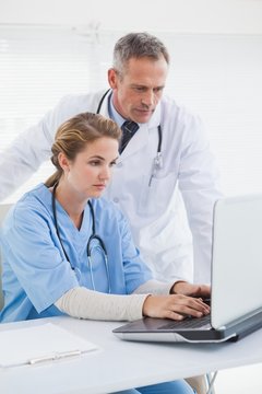 Nurse and doctor working on a laptop