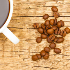 Wooden table with coffee cup and coffee beans - 1 to 1 ratio