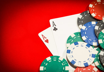 Obraz premium Pair of aces and chips on a red table