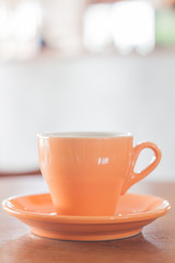 Orange mug on wooden table