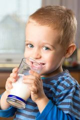 Young boy drinking milk out of glass