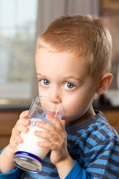 Young boy drinking milk out of glass