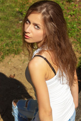 Fototapeta premium beautiful sexy girl with long hair in a white t-shirt and jeans