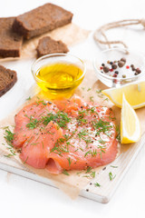 appetizer - salted salmon and bread on a wooden board, vertical