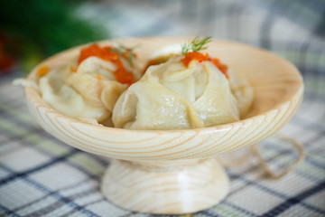 large boiled manti in the wooden saucer