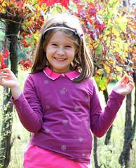 pretty little girl in the vineyard in autumn