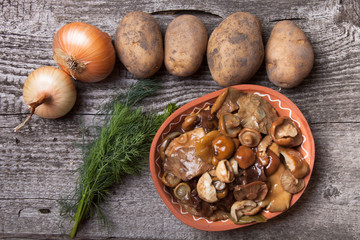 Salty mashrooms, potato, onion, dill and grain in a bowl on a ol