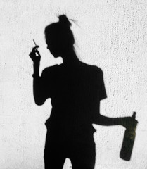  Shadow of sad girl smoking around on wall background