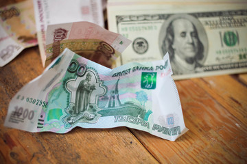 Crumpled scattered Russian rubles and dollars