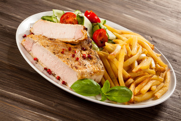 Fried pork chop, chips and vegetable salad