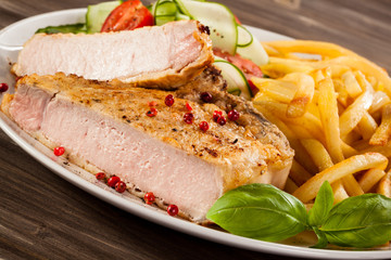 Fried pork chop, chips and vegetable salad