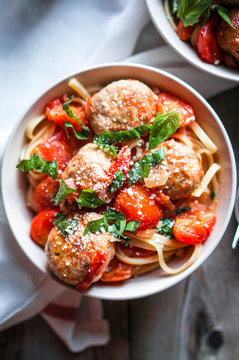 Pasta with meatballs on rustic background