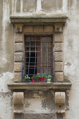 Fototapeta na wymiar Medieval window with heavy wrought-iron grilles