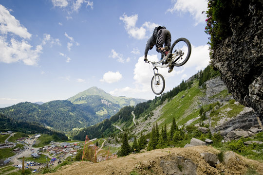 Mountainbiker jumping from a rock