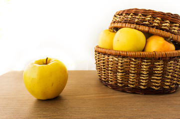 Fresh apples in basket on wooden background