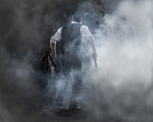 going to work,businessman walking in the haze , gun and bag