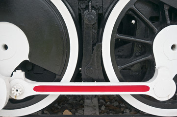 Black wheel of train with white and red mechanism