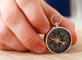 Man&#39;s hand holding a compass.