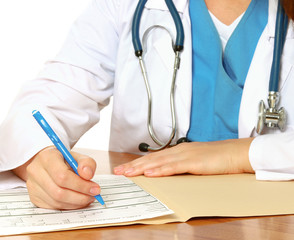 Young female doctor at desk isolated on white background