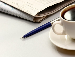cup near newspapers.
