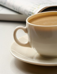 cup near newspapers