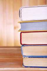 Books on wooden table on wooden wall background