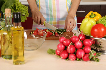 Woman cooking vegetable salad in kitchen