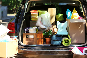 Moving boxes and suitcases in trunk of car, outdoors