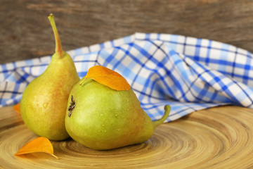 Ripe tasty pears on wooden plate