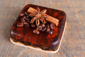 Organic soap with coffee beans and spices on wooden background
