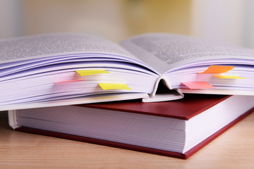 Books with bookmarks on table on bright background