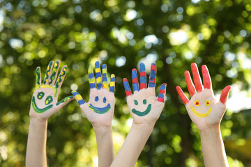 Smiling colorful hands on natural background