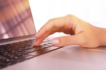 Female hands on laptop, close-up