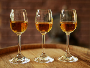 Glasses of wine in cellar with old barrels