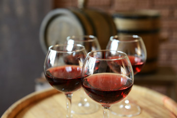 Glasses of wine in cellar with old barrels