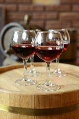 Glasses of wine in cellar with old barrels