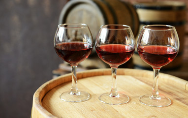 Glasses of wine in cellar with old barrels