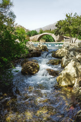 Fototapeta na wymiar Старинный мост через горную реку.