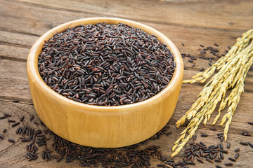 Black rice in bowl on wooden table
