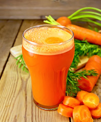 Juice carrot with leaf on board