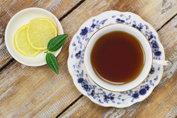 Tea in vintage cup on wooden surface